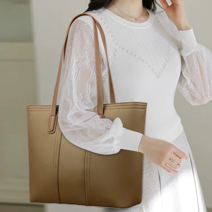 Klassisk brun shopperväska för dam med eleganta sömmar. Långa axelremmar och rymlig design gör den både praktisk och tidlös.