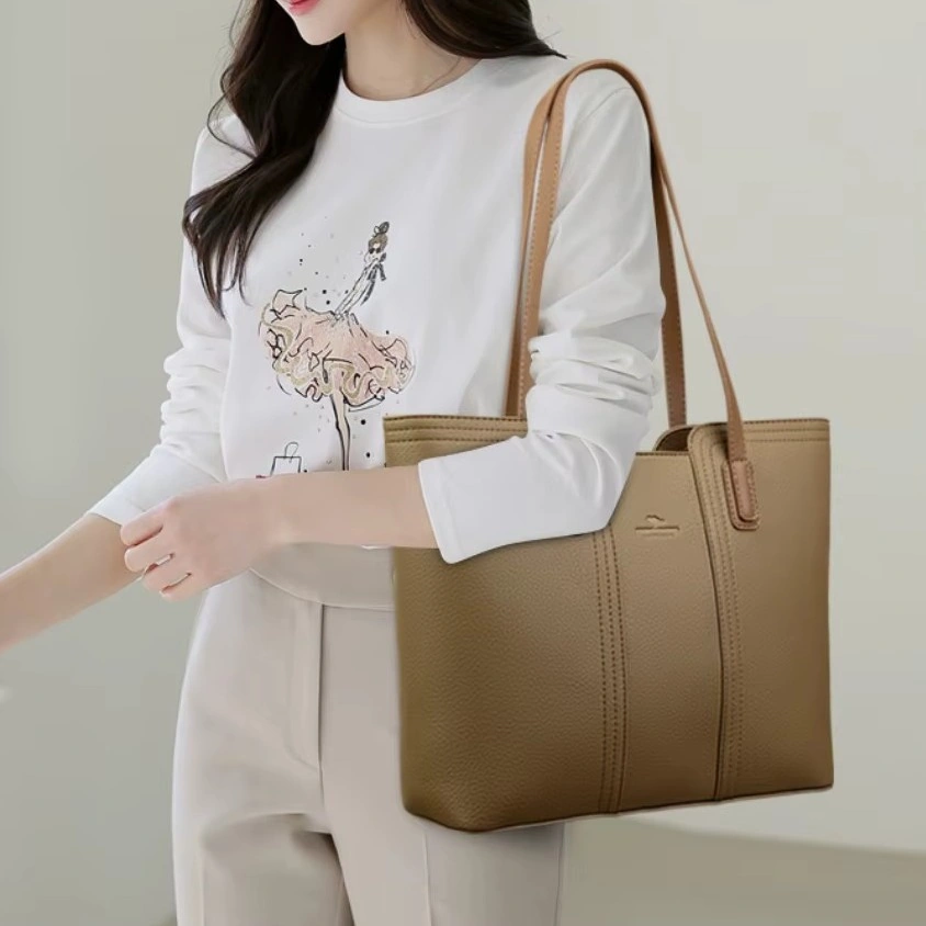 Stilren shopperväska dam i kaffe-tonat PU-läder. Bekväm att bära över axeln, med plats för vardagens viktigaste tillbehör.