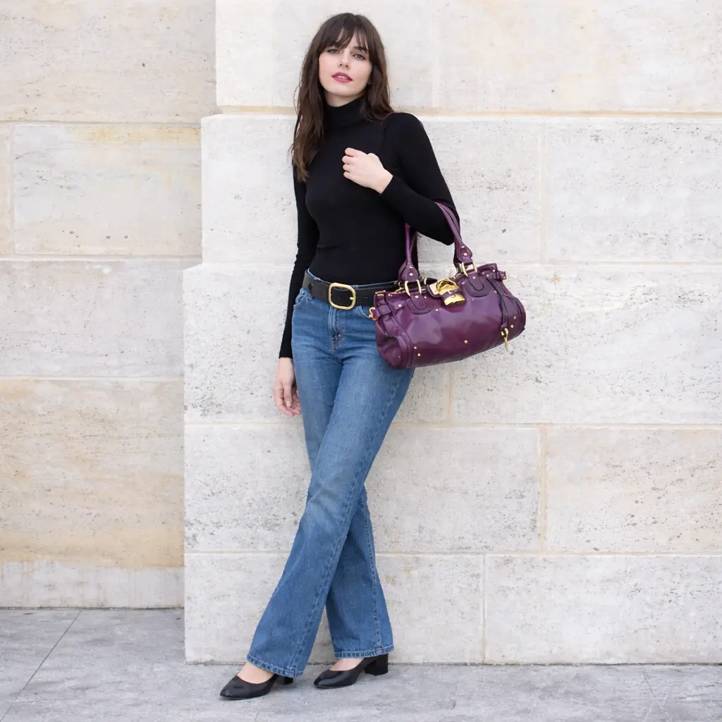 Elegant vinröd Chloé Paddington handväska från 2004, buren med modern outfit. Ikonisk design som åter blir trendig 2026.