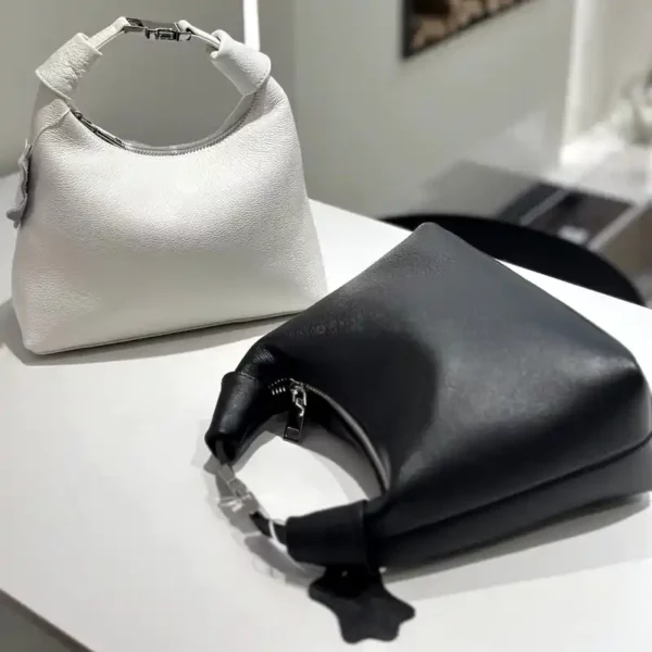 Svart och vit handväska dam i äkta skinn med modern siluett, metallspänne och rund öppning