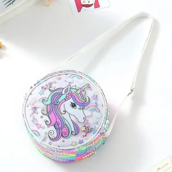 Vit rund barnväska med glittrig yta och regnbågsdetaljer. Lätt modell i polyester med dragkedja och bekväm axelrem.